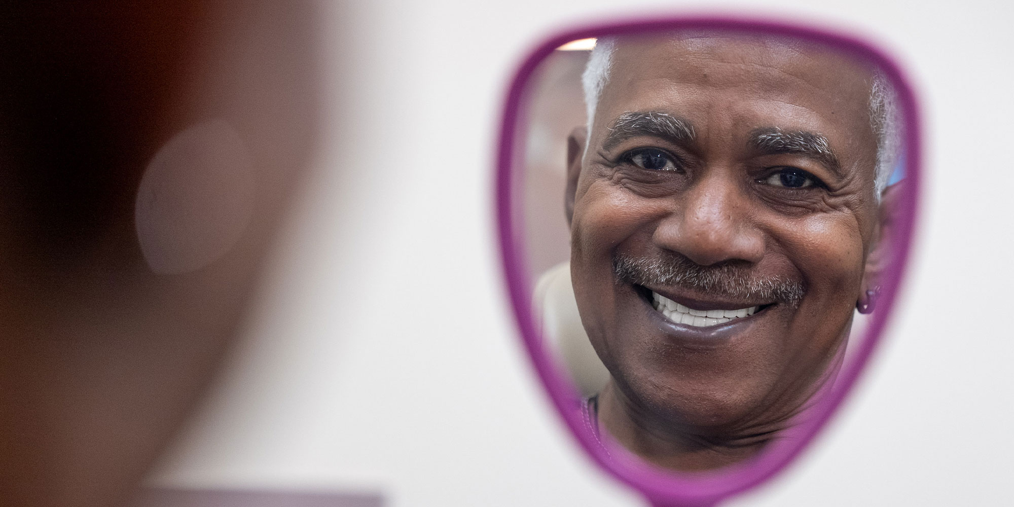 patient looking at their teeth after teeth whitening